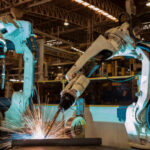 Team robots are welding assembly  part in factory